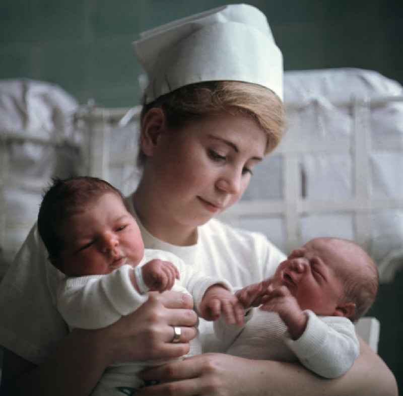 Eine Krankenschwester in einem Krankenhaus in Berlin-Kaulsdorf hält zwei Neugeborene in ihren Armen.