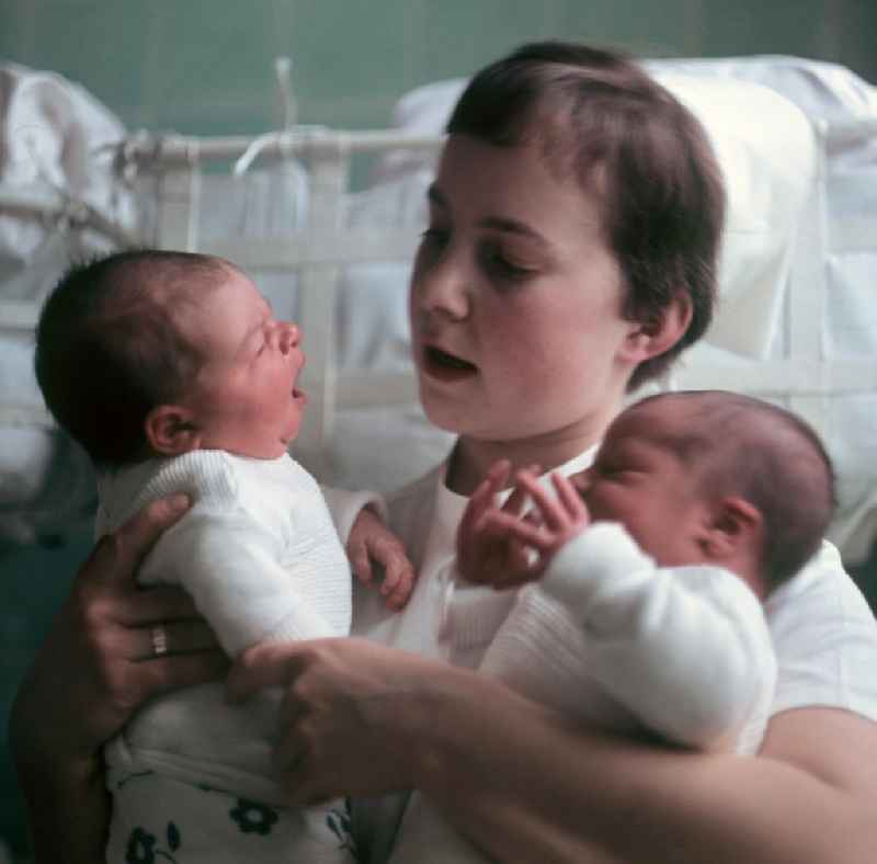 Eine Krankenschwester in einem Krankenhaus in Berlin-Kaulsdorf hält zwei Neugeborene in ihren Armen.
