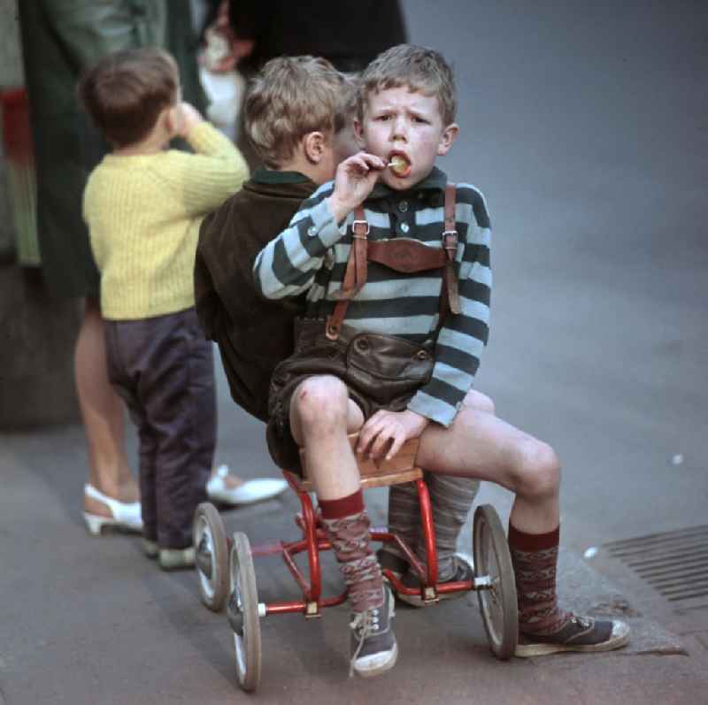Kinder essen einen Lutscher und warten in der Dimitroffstraße, heute Danziger Straße, in Berlin auf die Fahrer der ersten Etappe der 21. Internationalen Friedensfahrt. Die Friedensfahrt 1968 begann in Berlin und führte über Prag nach Warschau.