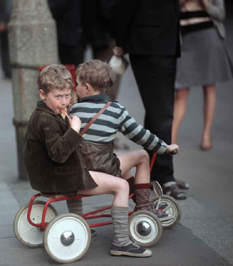 Kinder essen einen Lutscher und warten in der Dimitroffstraße, heute Danziger Straße, in Berlin auf die Fahrer der ersten Etappe der 21. Internationalen Friedensfahrt. Die Friedensfahrt 1968 begann in Berlin und führte über Prag nach Warschau.