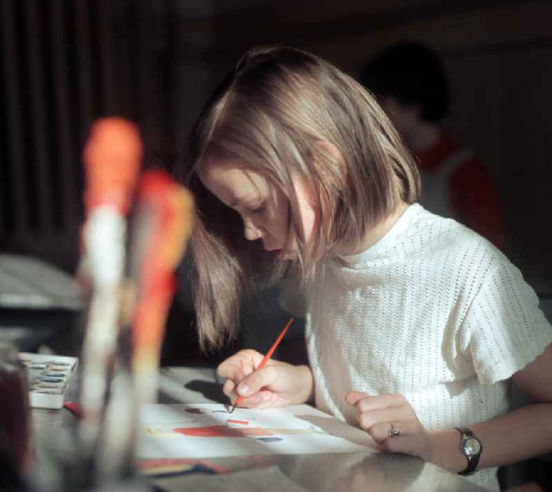 Ein Mädchen zeichnet im Kunstunterricht mit Tusche ein Bild.