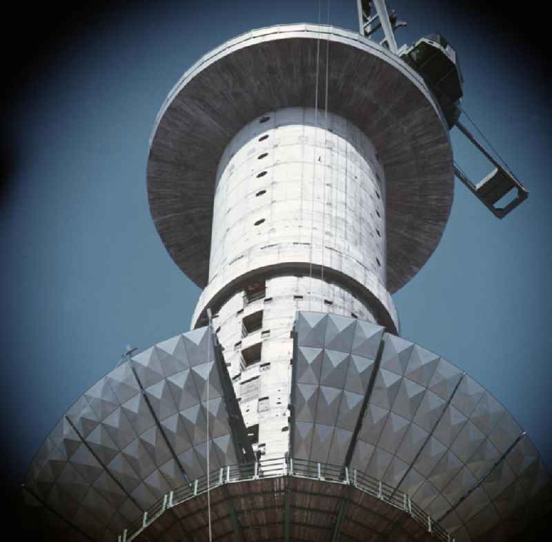 Die Segmente der Kugel des Fernsehturms in Berlin werden mit einem Spezialkran nach oben transportiert und dann montiert. Die erste Reihe der Kugel ist fast abgeschlossen.