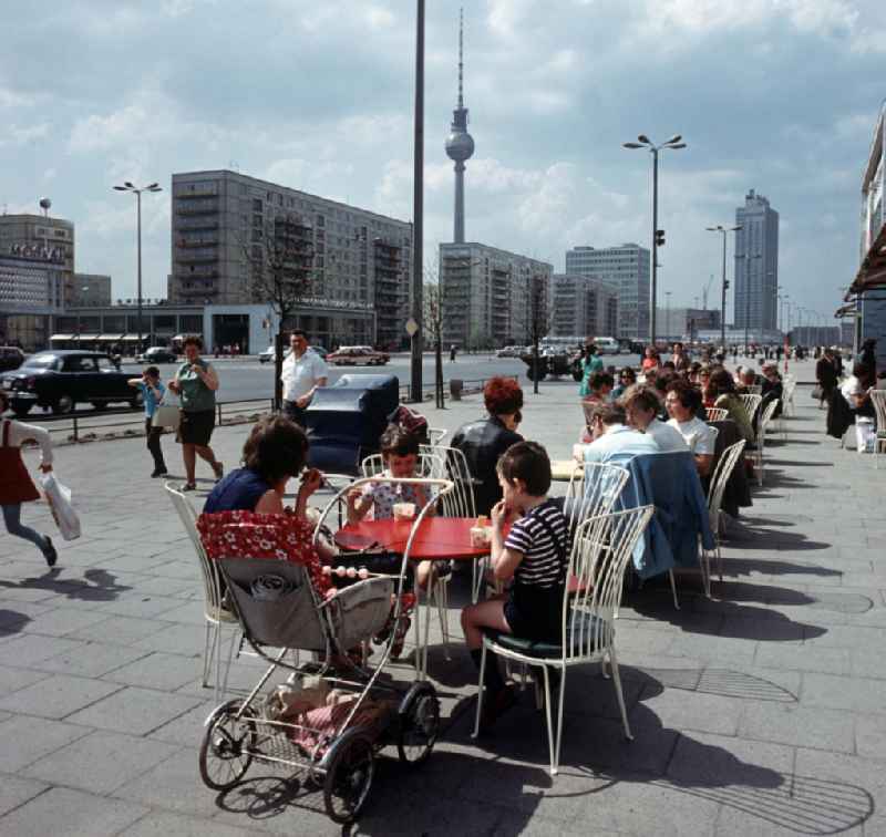 Moderne Neubauten sollen Ost-Berlin als Hauptstadt der DDR das Antlitz einer sozialistischen Großstadt verleihen - hier Familien beim Eisessen im beliebten Café Moskau an der Karl-Marx-Allee. Der bestehende Wohnungsmangel entwickelte sich in der DDR seit den 6