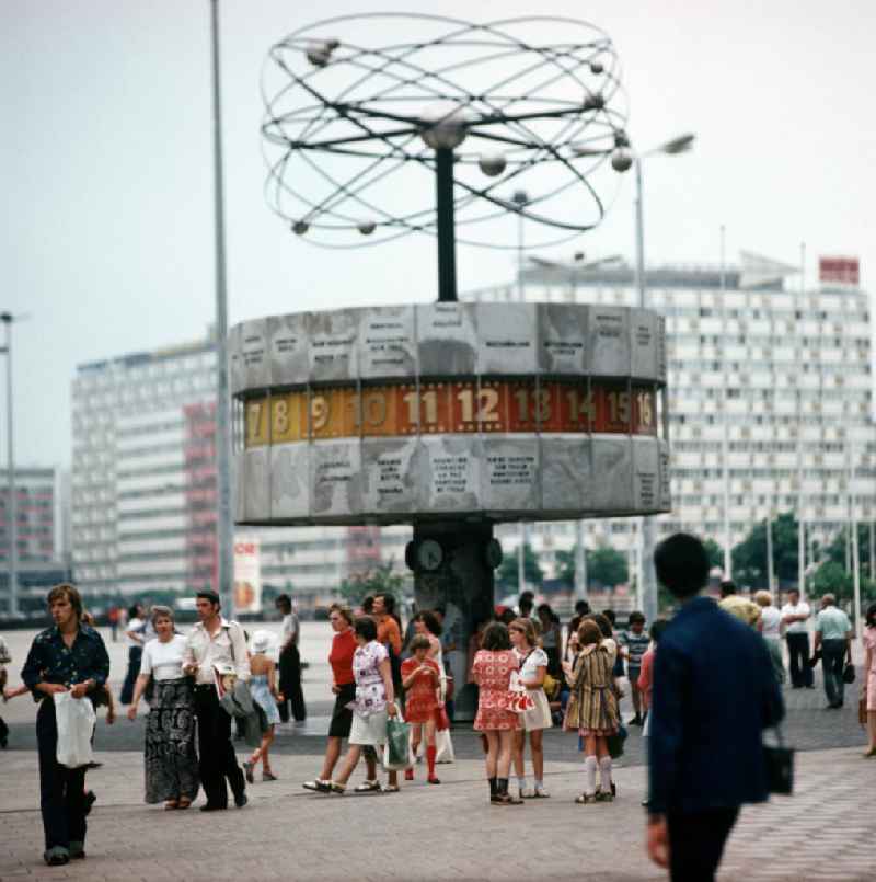 Touristen und Einheimische flanieren über den Berliner Alexanderplatz und besichtigen die Weltzeituhr.