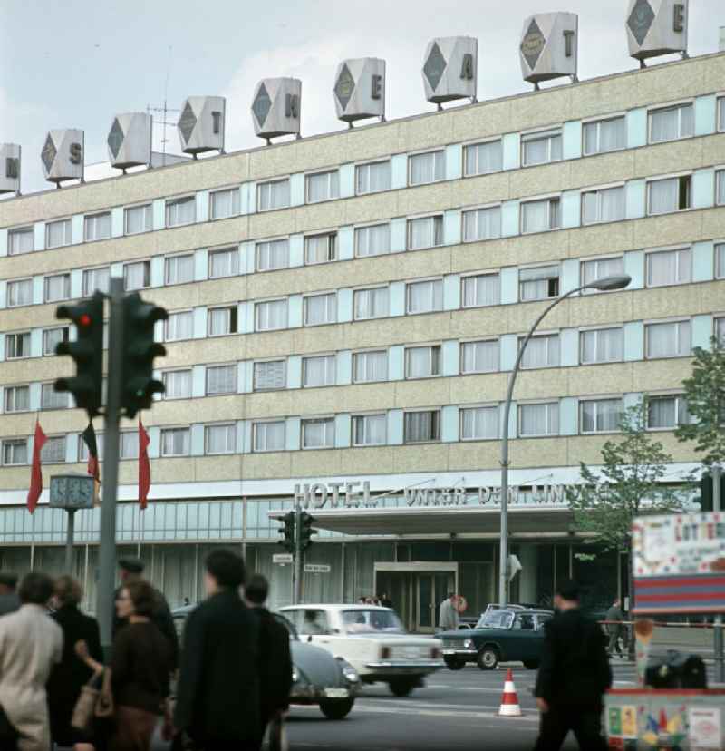 Passanten überqueren Ost-Berlins beliebteste Flaniermeile Unter den Linden, im Hintergrund das Hotel Unter den Linden. Das Mitte der 60er Jahre errichtete Hotel an der Friedrichstraße / Ecke Unter den Linden war eines der ersten Neubauten der Interhotel-Kette der DDR. Das Gebäude wurde 20
