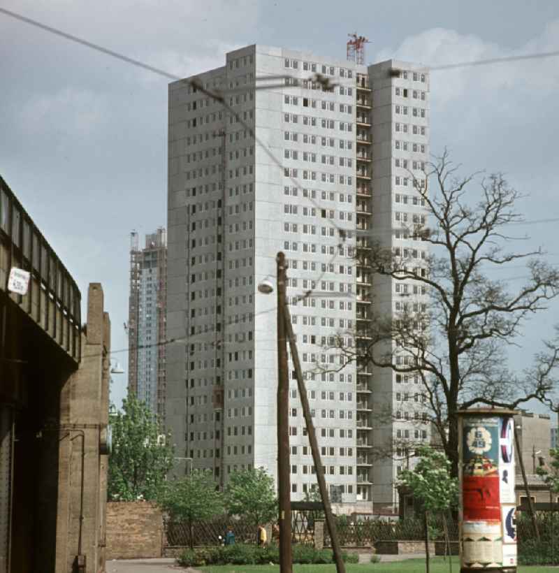 Moderne Neubauten sollen Ost-Berlin als Hauptstadt der DDR das Antlitz einer sozialistischen Großstadt verleihen - hier das neuerrichtete Hochhaus an der Rochstraße nahe S-Bahnhof Hackescher Markt, im Hintergrund das Hotel Stadt Berlin im Bau. Der bestehende Wohnungsmangel entwickelte sich in der DDR seit den 6