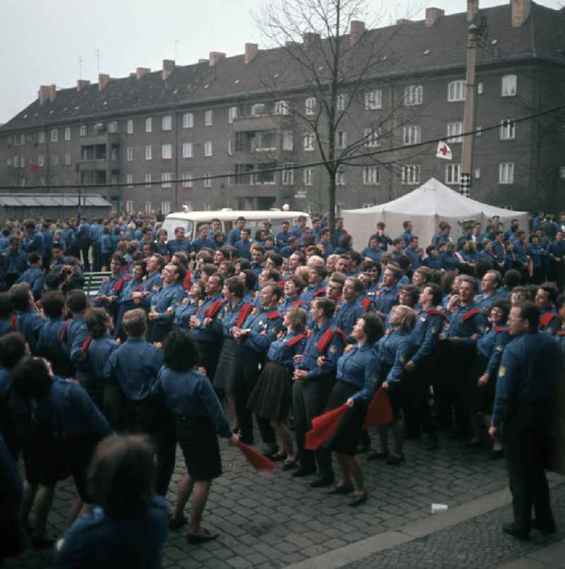 Auf einer Jugenddemonstration singen und tanzen FDJler in Uniform zur Musik eines Akkordeons in Berlin.