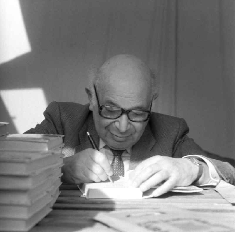 Der deutsch-jüdische Schriftsteller Rudolf Hirsch signiert auf dem Schriftstellerbasar in Berlin seine Bücher.