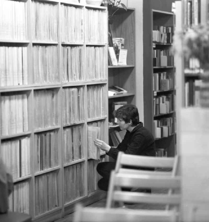 Eine Frau sucht in einer Bibliothek in Berlin-Mahlsdorf die richtige Schallplatte zum Ausleihen.