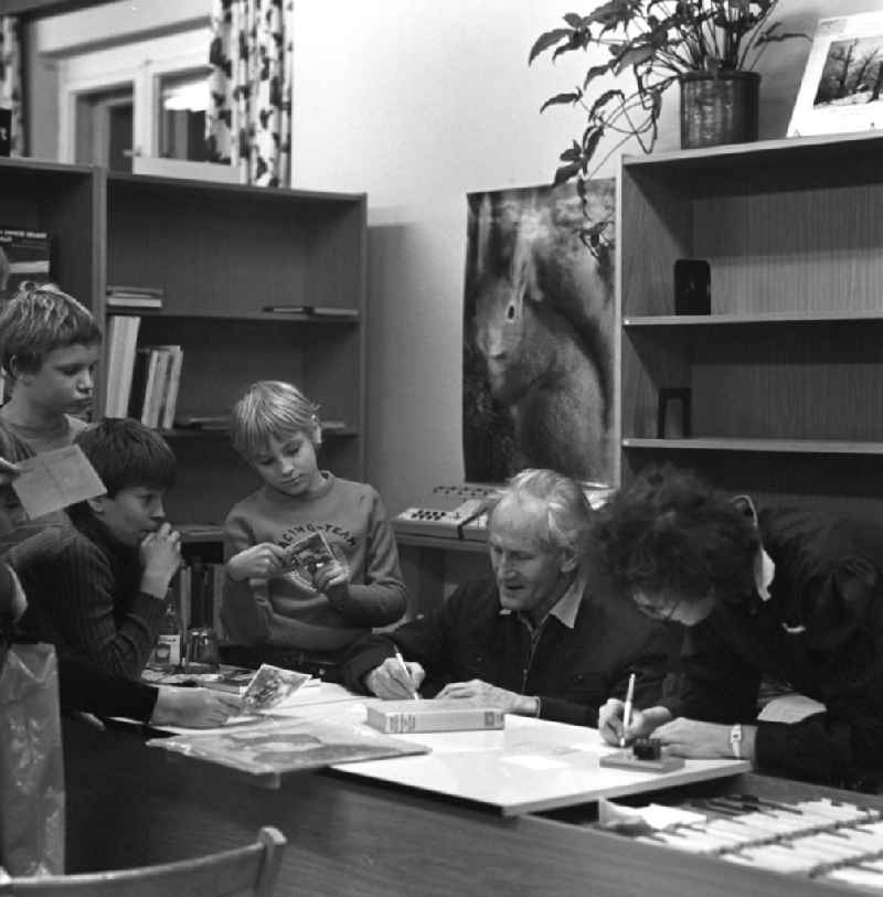 Der Komponist Kurt Schwaen verteilt in einer Bibliothek in Berlin-Mahlsdorf an eine Schülergruppe Autogramme.