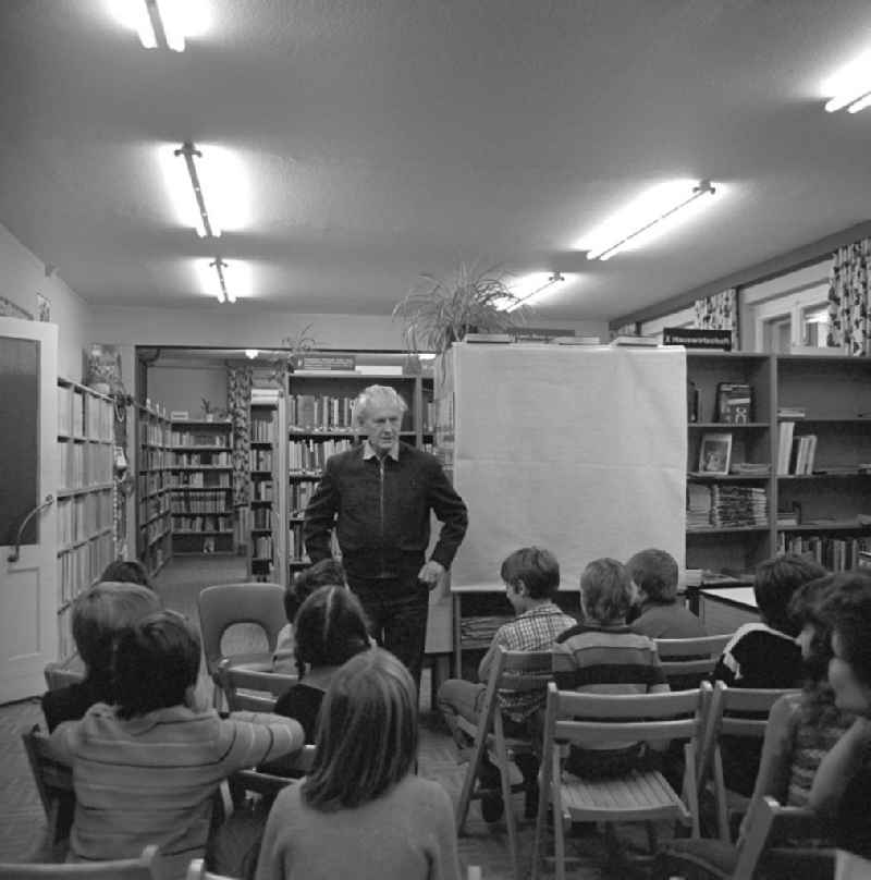 Der Komponist Kurt Schwaen erklärt in einer Bibliothek in Berlin-Mahlsdorf einer Schülergruppe seine Musik.