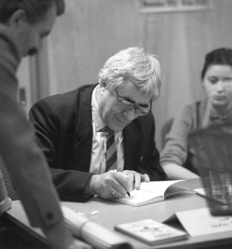 Der Schriftsteller John Stave signiert ein Buch in der Buchhandlung 'Internationales Buch' in Berlin.