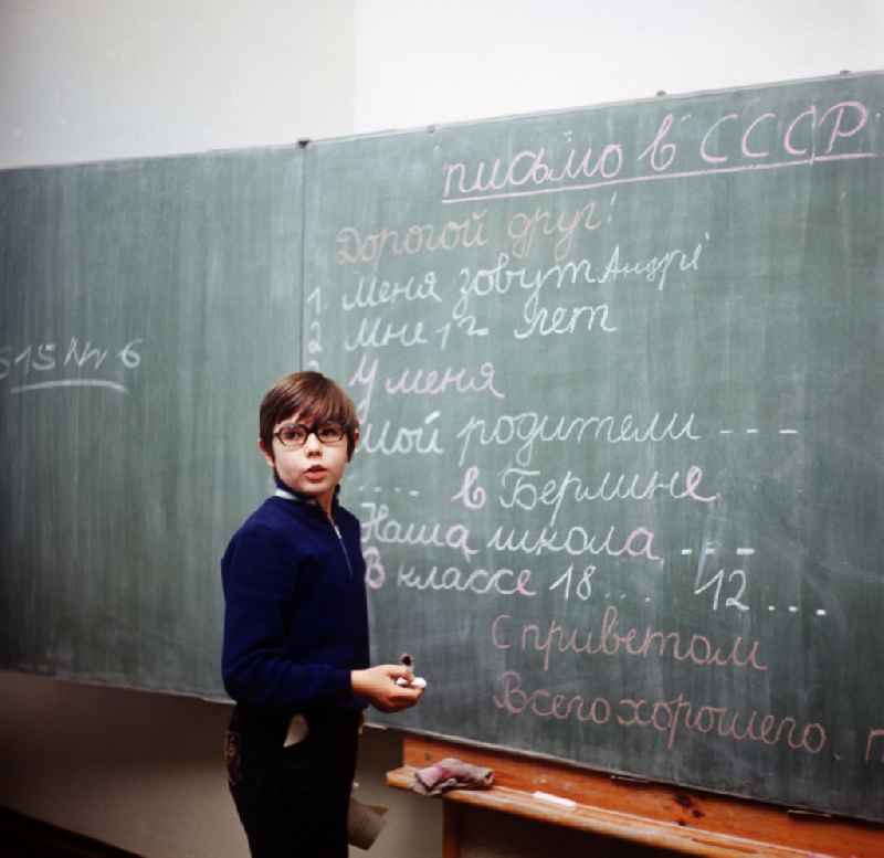 Boy with glasses in the Russian class at the blackboard