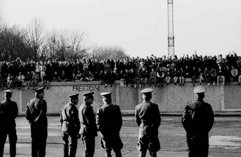 Occupation of the tank wall at the front of the Brandenburg Gate in Berlin-Mitte. Several hundred people from West Berlin climbed and occupied the meter-high concrete barriers of the GDR border on the square in front of the Berlin landmark under the eyes of onlookers soldiers of the Border Troops of the GDR