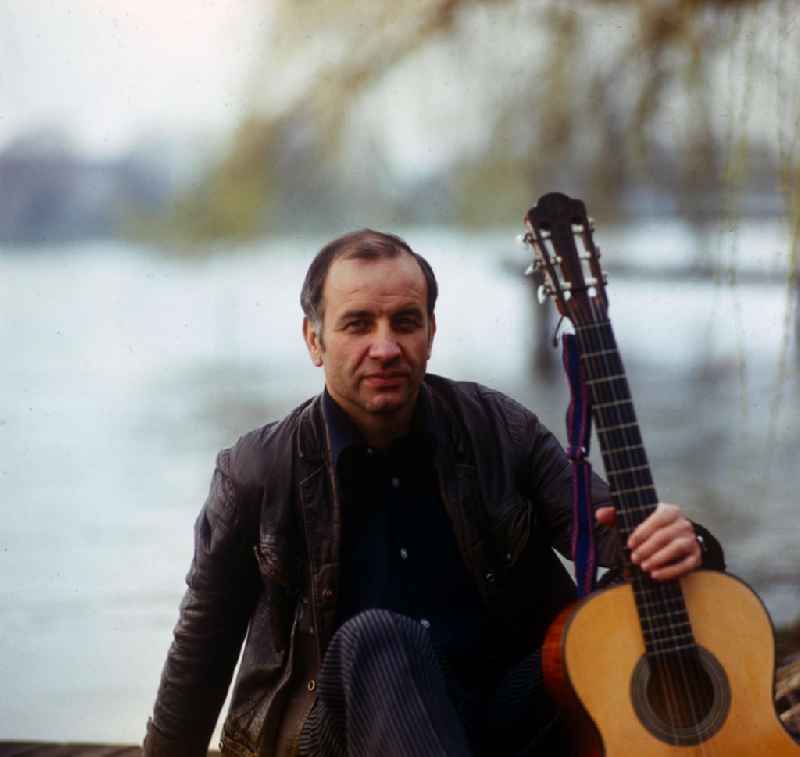 Actor Armin Mueller-Stahl in the guitar playing on the banks of the Dahme River in Berlin - Koepenick