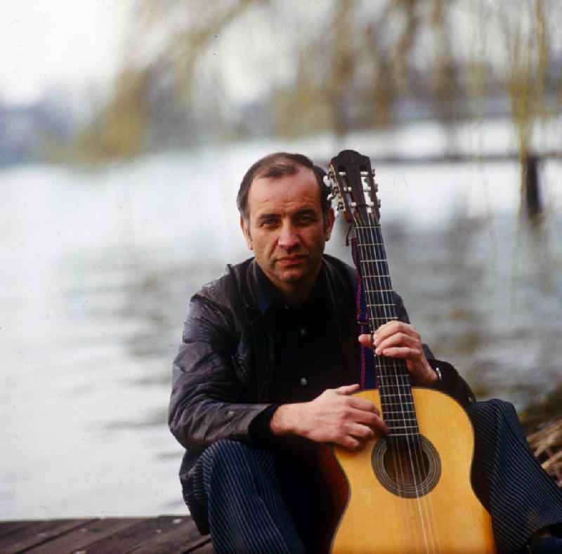 Actor Armin Mueller-Stahl in the guitar playing on the banks of the Dahme River in Berlin - Koepenick