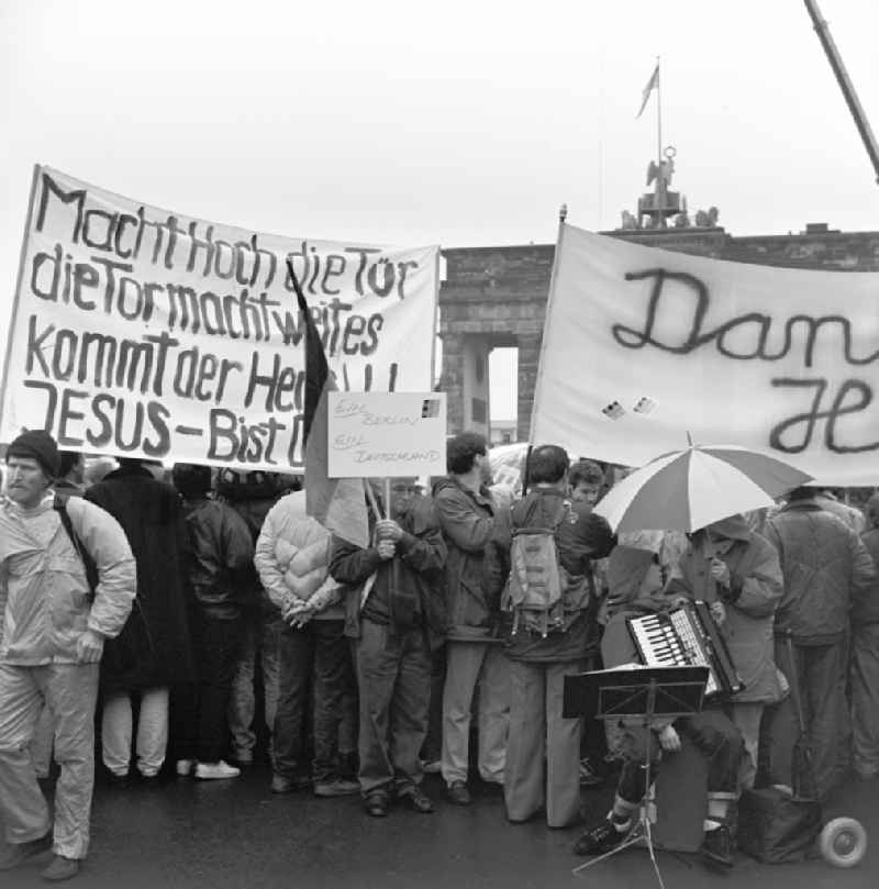 Happening around the Brandenburg Gate shortly before the opening on the occasion of the Berlin Wall in November 1989 in Berlin. Crowds with bannes before the Wall at Brandenburg Gate