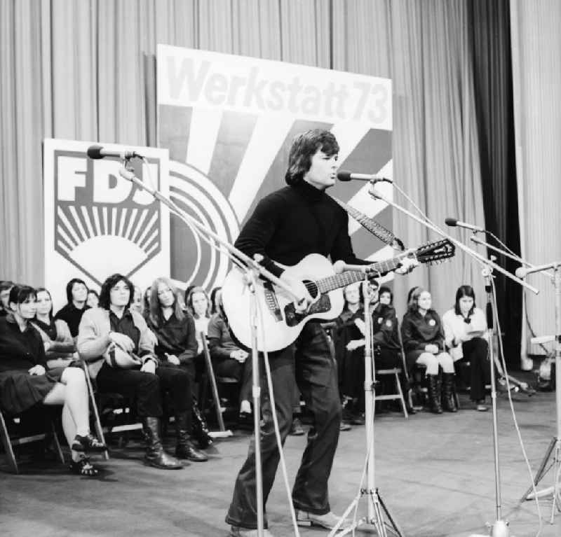 Singer Dean Reed sings with guitar on the final concert of the 'Werktatt 73' FDJ-singing clubs in the movie theater Kosmos in Berlin-Friedrichshain