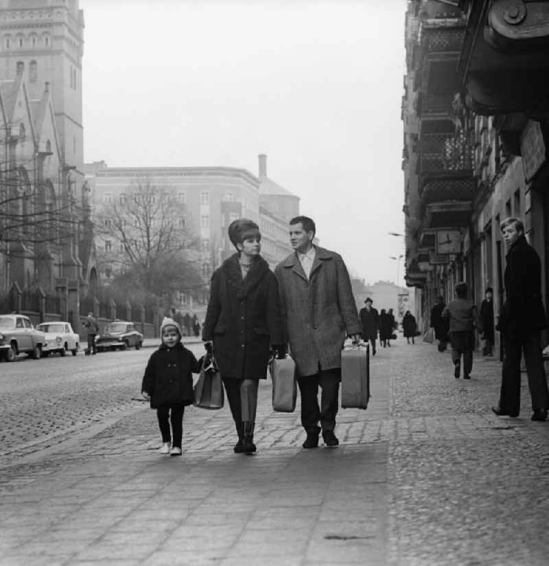 Young family traveling with suitcases in Berlin-Prenzlauer Berg