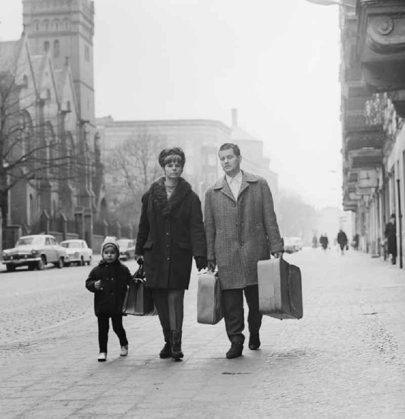 Young family traveling with suitcases in Berlin-Prenzlauer Berg