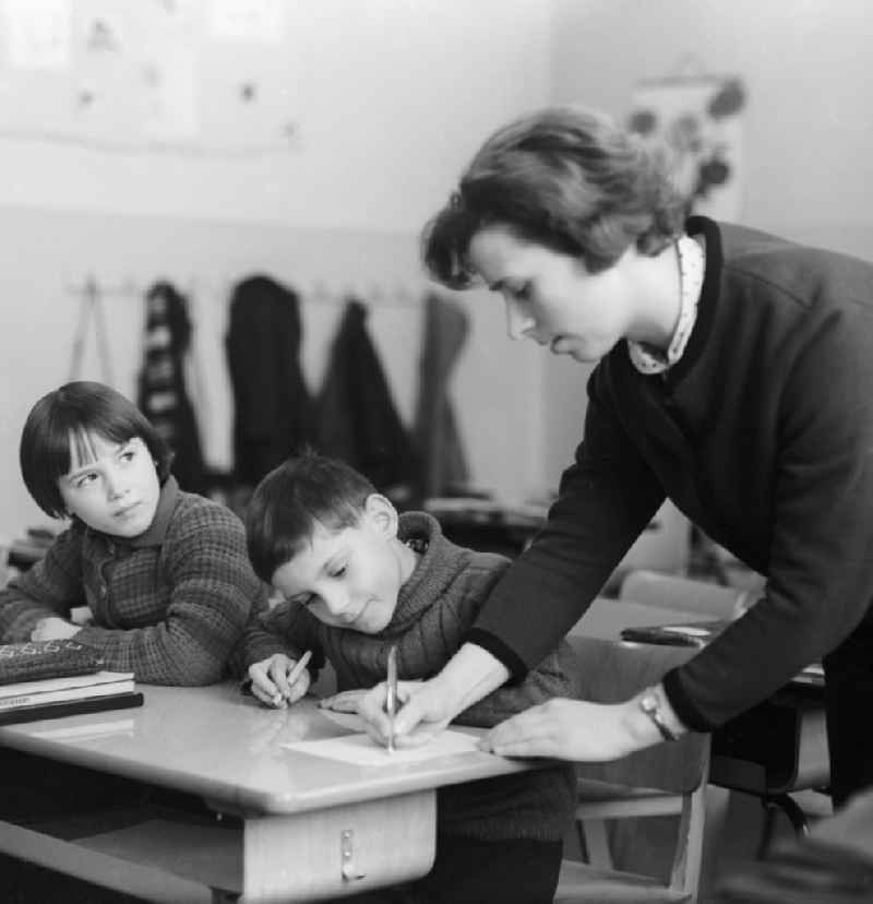 Teacher corrects homework pupils in the classroom in Berlin