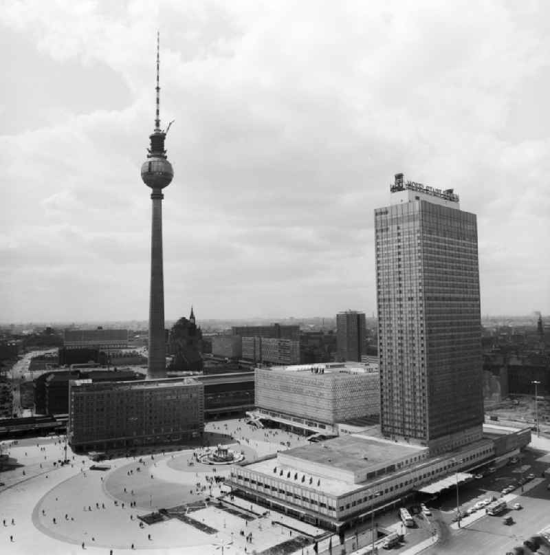 View at the Alexanderplatz with the TV tower in Berlin - Mitte. In the foreground the Hotel Stadt Berlin (now known as Park Inn by Radisson), behind the Centrum department store (now Galeria Kaufhof) next to the Alexander House and the S- and U-Bahn station Alexanderplatz. Centrally located in the middle of Alexanderplatz find the Fountain of Friendship of Nations