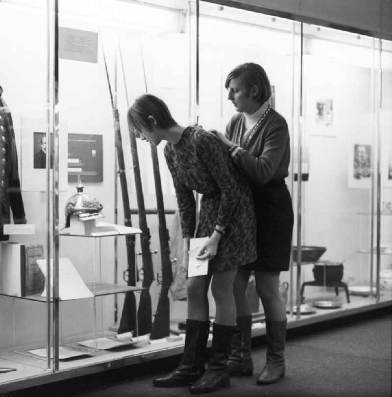 Young people at the Museum of German History in Berlin. Here are two young women in front of a display case with flared arms of the civil war