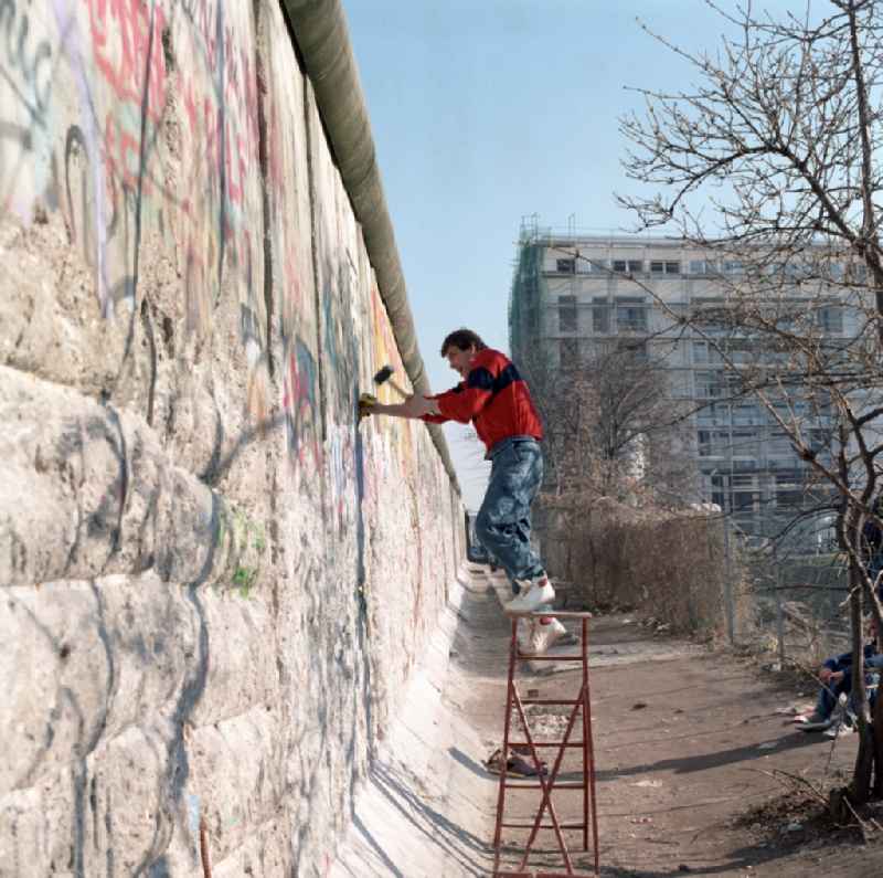 Wallpeckers and souvenir collectors at the Berlin Wall in Berlin. As wallpeckers people were popularly known, the edited the Berlin Wall after the Wall fell in 1989 and crushed