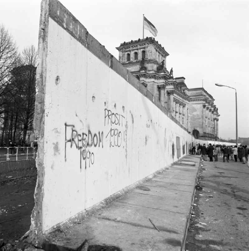 Tourists and Berlin citizens see the demolition of the Berlin Wall at the Reichstag building in Berlin
