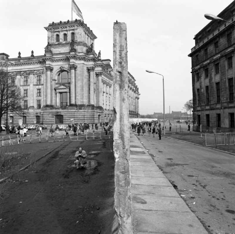 Tourists and Berlin citizens see the demolition of the Berlin Wall at the Reichstag building in Berlin