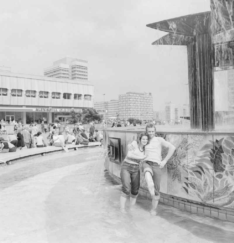 Young Couple barefoot in the People's Friendship Fountain in Alexanderplatz in Berlin