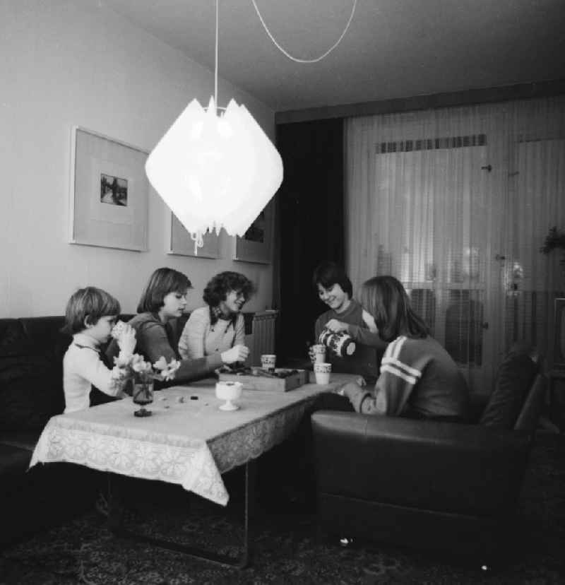 Young girls sitting at a table and play a board game in Berlin