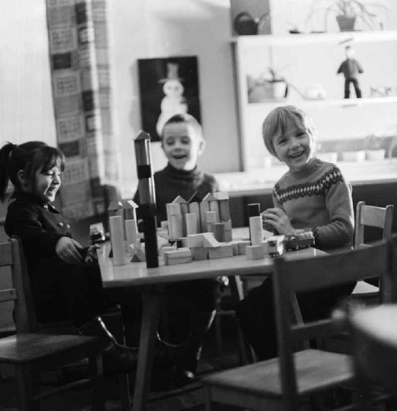 Kids playing with wooden blocks on a table in Berlin