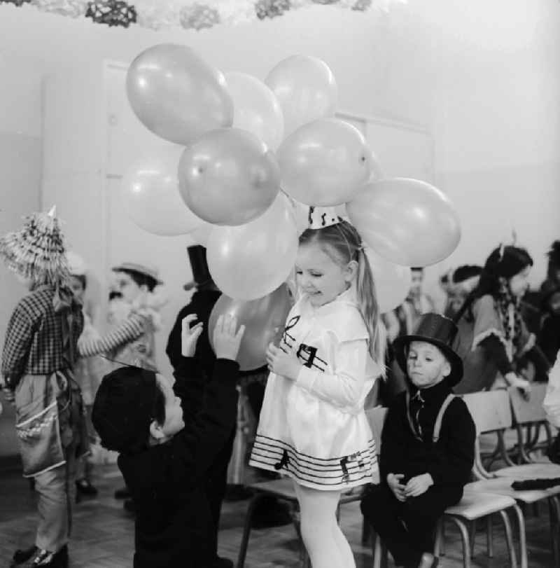 Carnival in kindergarten in Berlin. Girl with balloons and dressed as a note