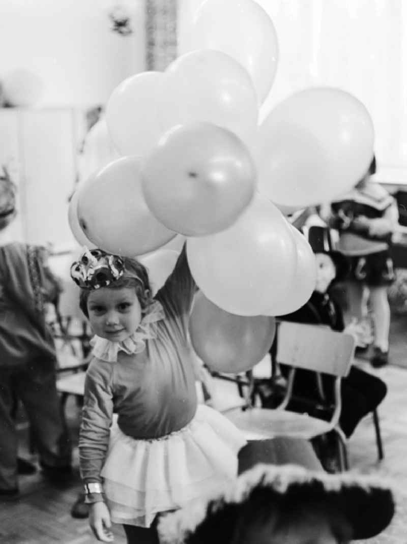 Carnival in kindergarten in Berlin. Girl with balloons and dressed as princess