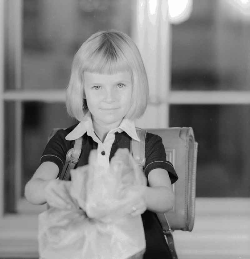 1st day of school - girl with sugar cube in Berlin, the former capital of the GDR, the German Democratic Republic