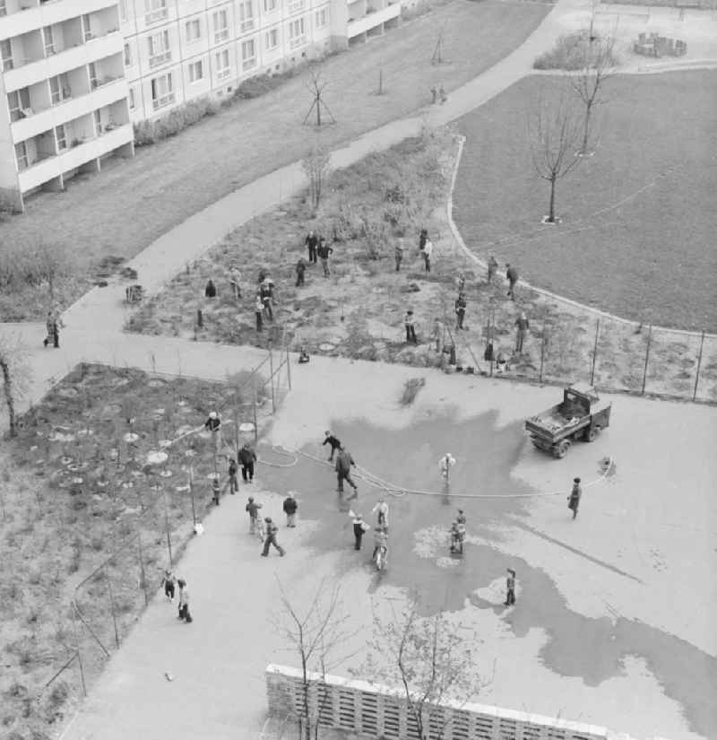 Subbotnik, voluntary labor in the courtyard in a new residential area in Berlin, the former capital of the GDR, the German Democratic Republic. This was • Annual spring cleaning in the cities, this waste was eliminated, streets were swept, planted trees and shrubs, and much more