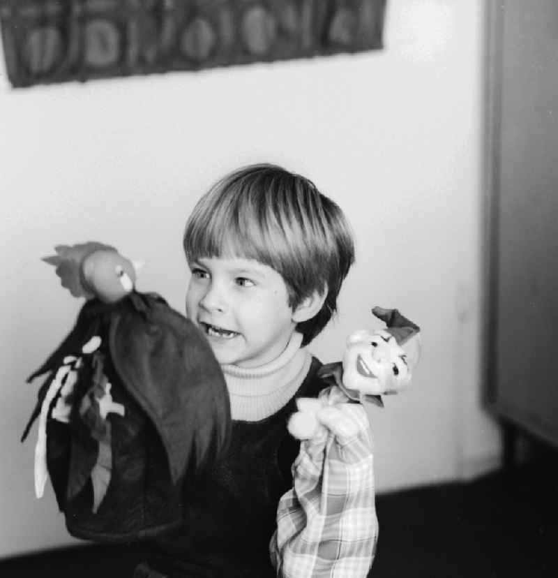 A child playing with hand puppets in Berlin, the former capital of the GDR, the German Democratic Republic