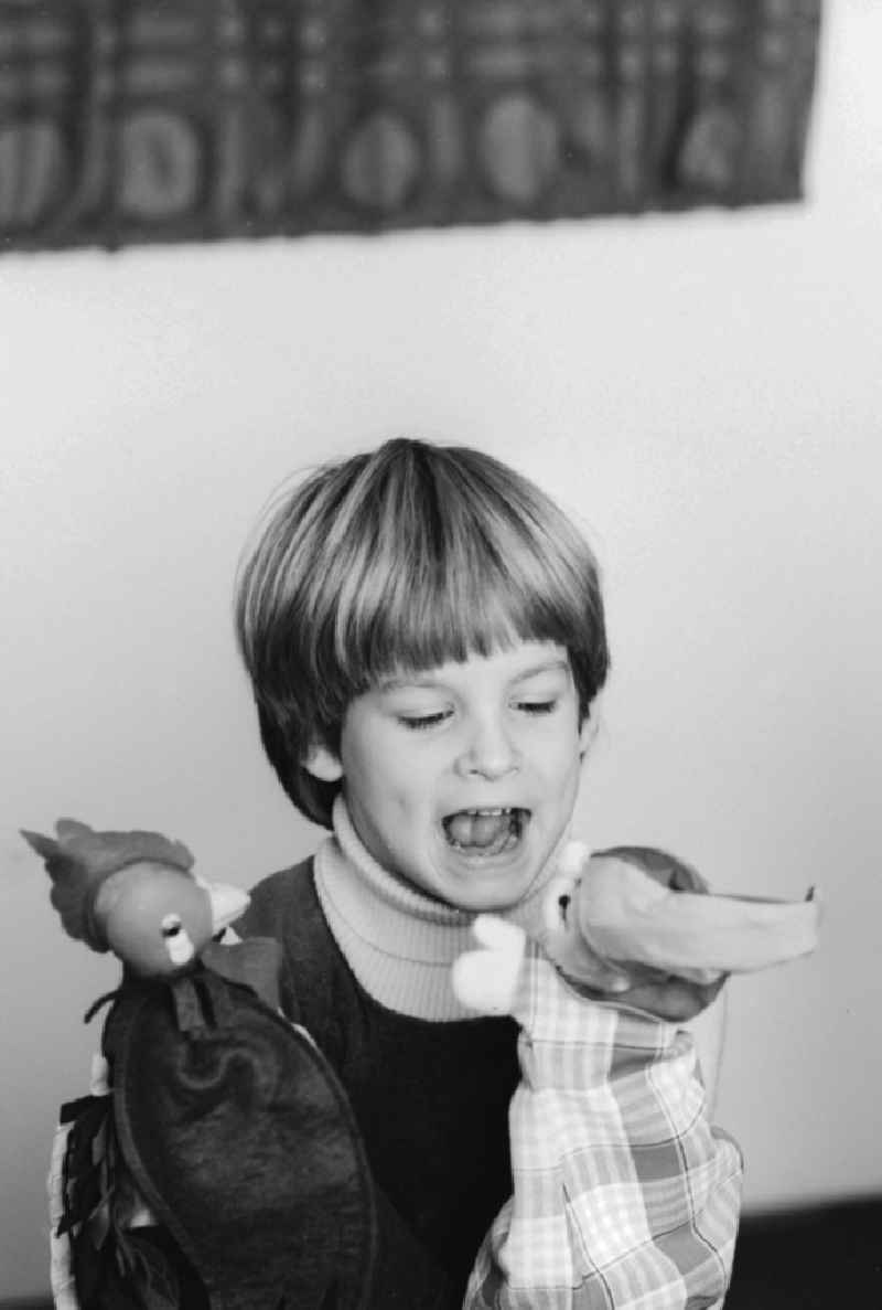 A child playing with hand puppets in Berlin, the former capital of the GDR, the German Democratic Republic