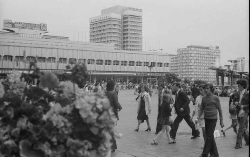 Tourists and Berlin strolling on the Alexanderplatz in Berlin, the former capital of the GDR, the German Democratic Republic. In the background is the high-rise of the House of Travel