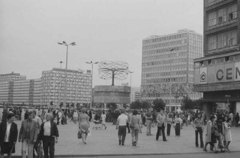 Tourists and Berlin at the world clock on the Alexanderplatz in Berlin, the former capital of the GDR, the German Democratic Republic. In the right background is the house of the teacher