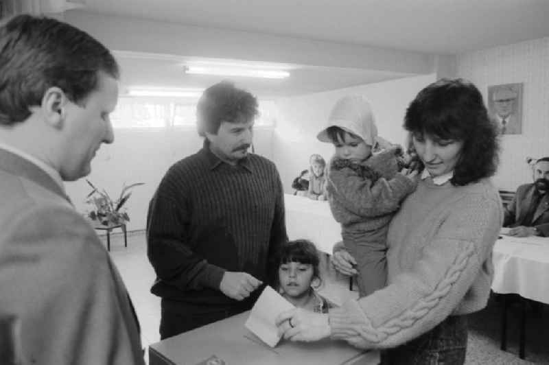 A young family with two small children standing at the ballot box at the polling station to the municipal elections in the GDR, in Berlin, the former capital of the GDR, the German Democratic Republic