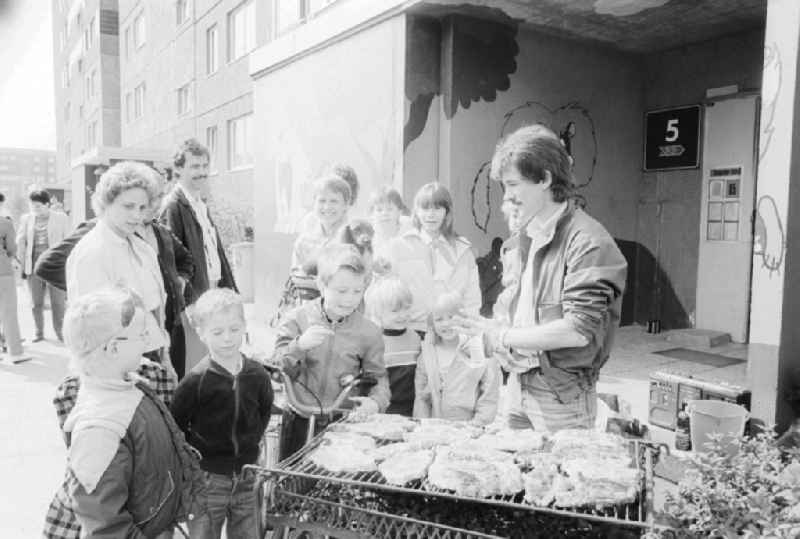 Tenants of a block of residential area barbecue in common on the doorstep in Berlin, the former capital of the GDR, the German Democratic Republic