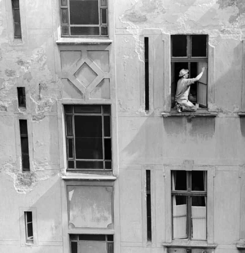 A painter sweeps window in a backyard in Berlin, the former capital of the GDR, the German Democratic Republic