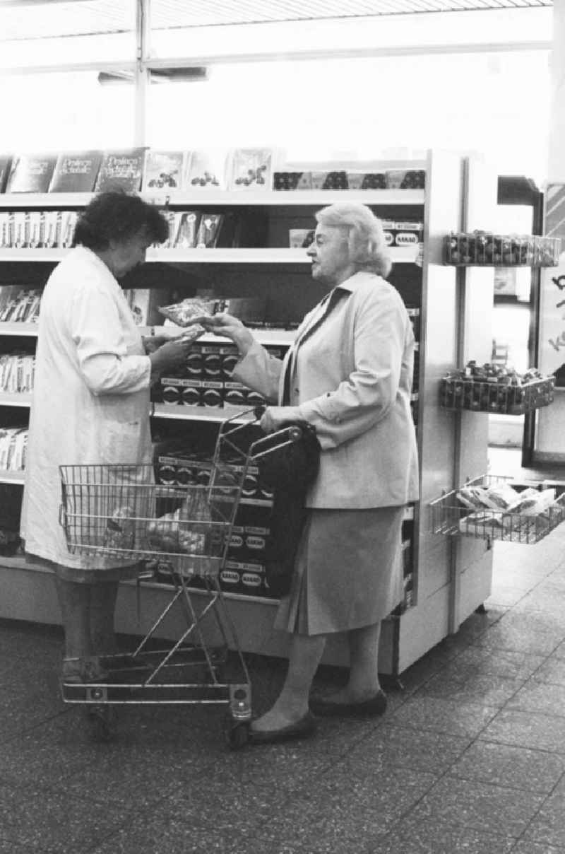 A woman shopping in a department store in Berlin, the former capital of the GDR, the German Democratic Republic. The shelves are filled partly with East products as well with Western products