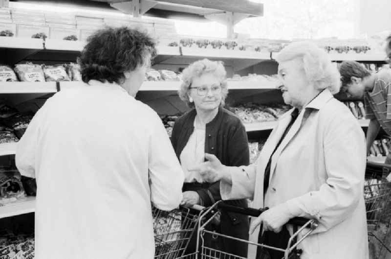 3 elderly ladies chatting in a department store in Berlin, the former capital of the GDR, the German Democratic Republic. The shelves are filled partly with Ostprodukten as well with Western products