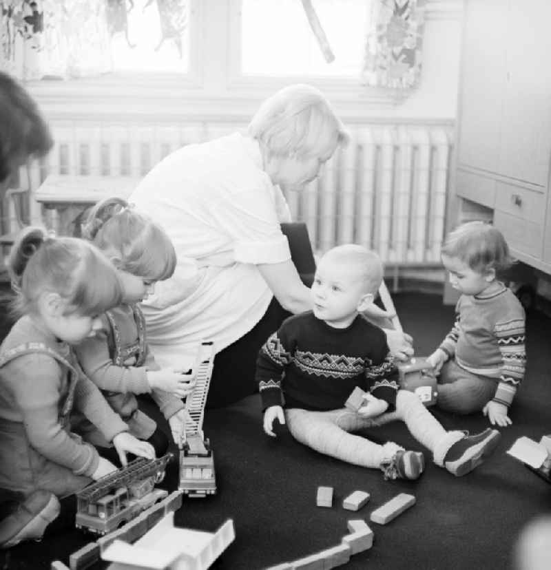 Children at the daily employment in the playroom at the Children's Clinic in Klinikum Berlin-Buch in Berlin, the former capital of the GDR, the German Democratic Republic. A mother sitting with her baby sits treatment rooms