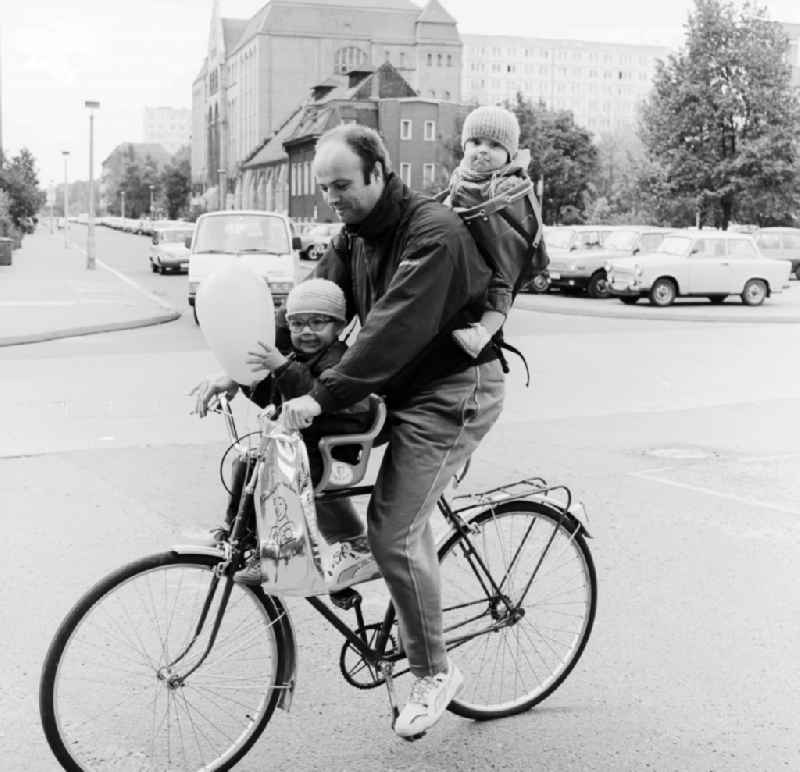 Father with two children on a bicycle in Berlin, the former capital of the GDR, German Democratic Republic
