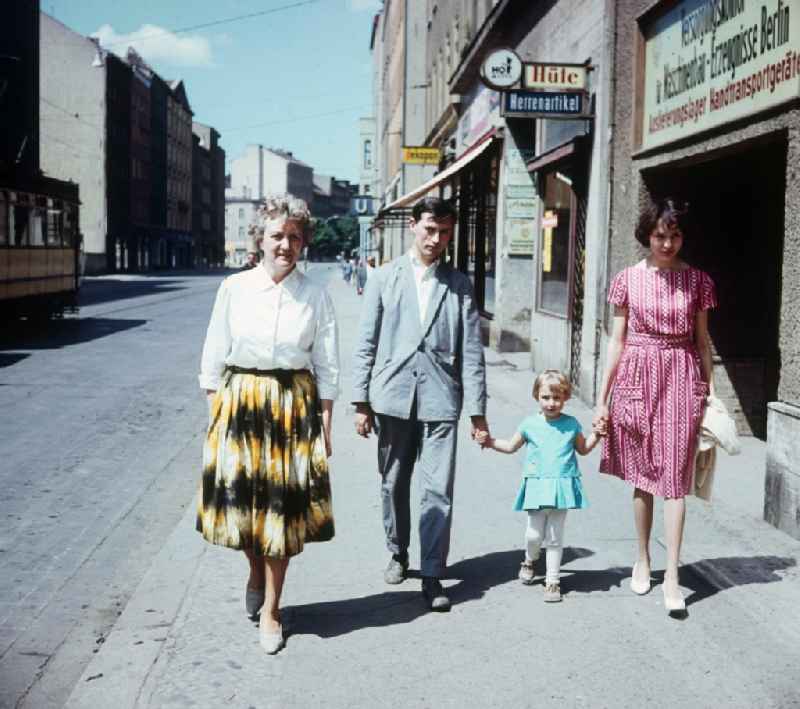 A young family strolls along Weinmeister street, near subway station Weinmeister street in Berlin, the former capital of the GDR, German democratic republic