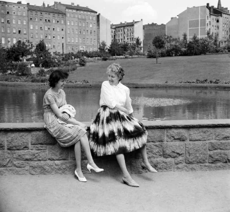 Two women sit in an artificial lake in Berlin, the former capital of the GDR, German democratic republic